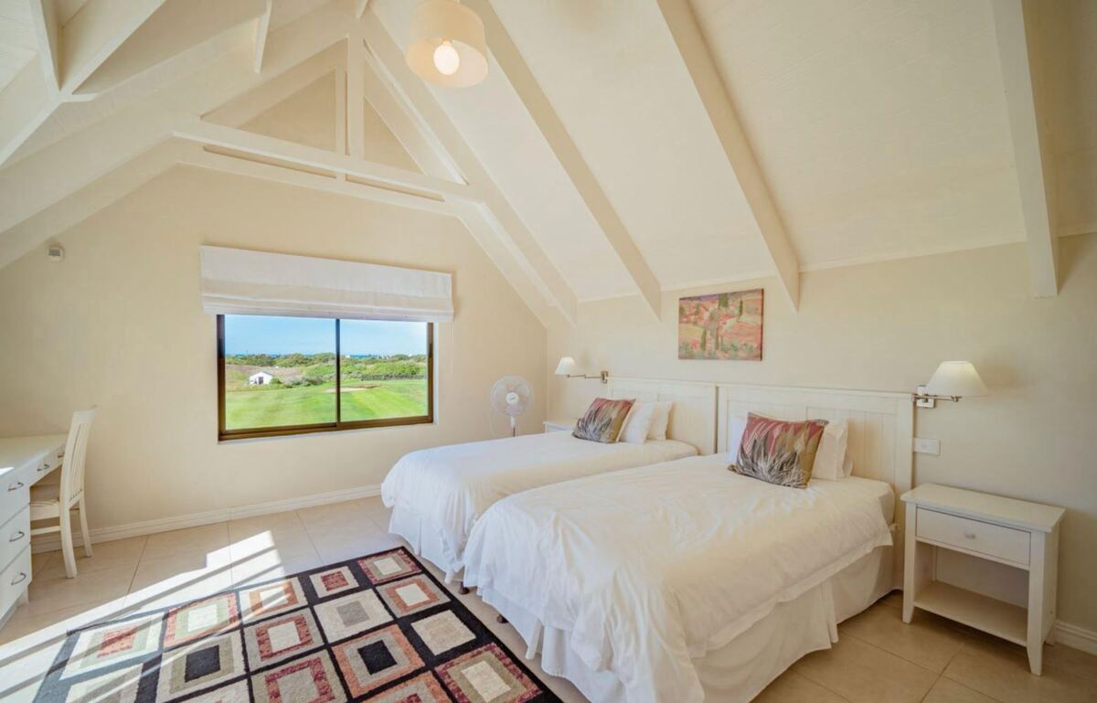 Twin bedroom with a window looking out towards the course